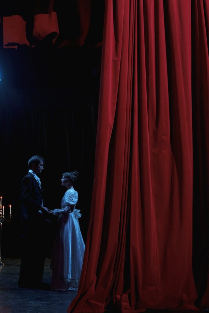 A captivating stage scene featuring a man and woman in romantic attire, lit by dramatic stage lights.
